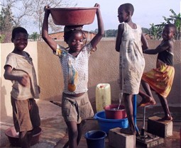  Kinder an einer Wasserpumpe in der Elfenbeinküste. 